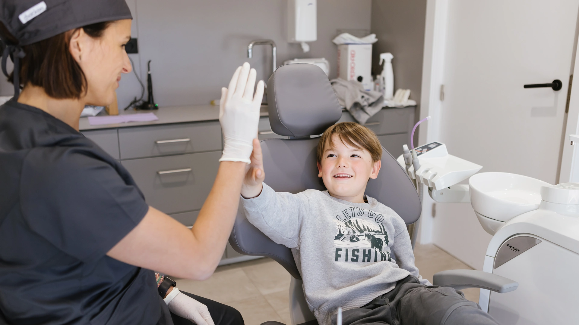 Primera visita al dentista infantil amb una família atesa en una consulta dental propera i tranquil·la