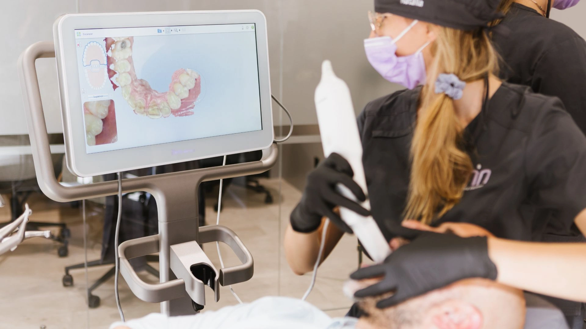 Dentista explicant opcions quan em falta un queixal pròtesi o implant amb model dental a consulta
