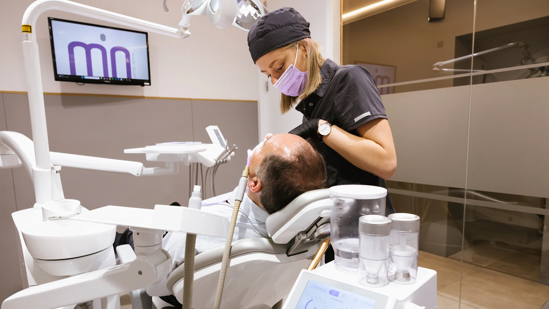 Dentista revisant genives sagnants amb un pacient adult en una consulta dental lluminosa