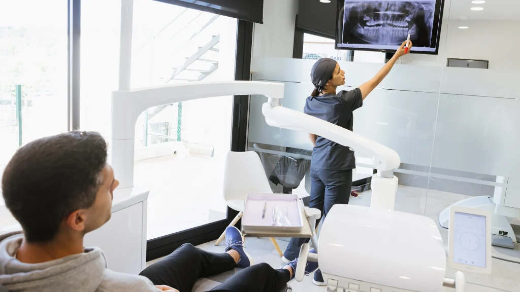 Dentista explicant cada quant convé fer una radiografia dental durant una revisió a la consulta