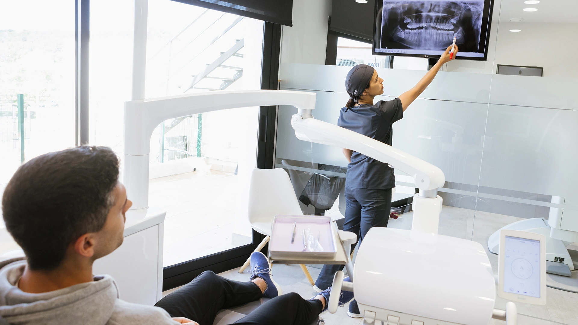 Dentista explicant cada quant convé fer una radiografia dental durant una revisió a la consulta