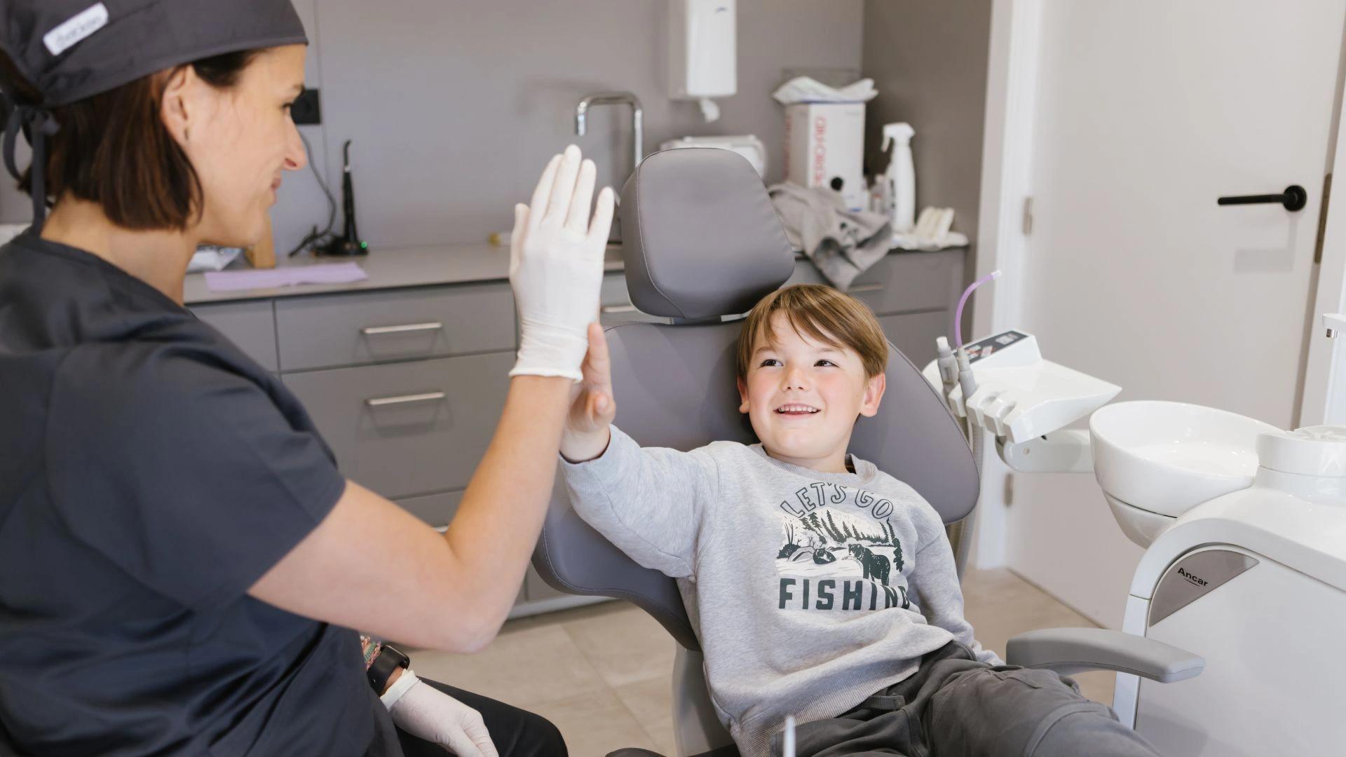 Infant amb por al dentista parlant amb una odontopediatra abans de començar la visita