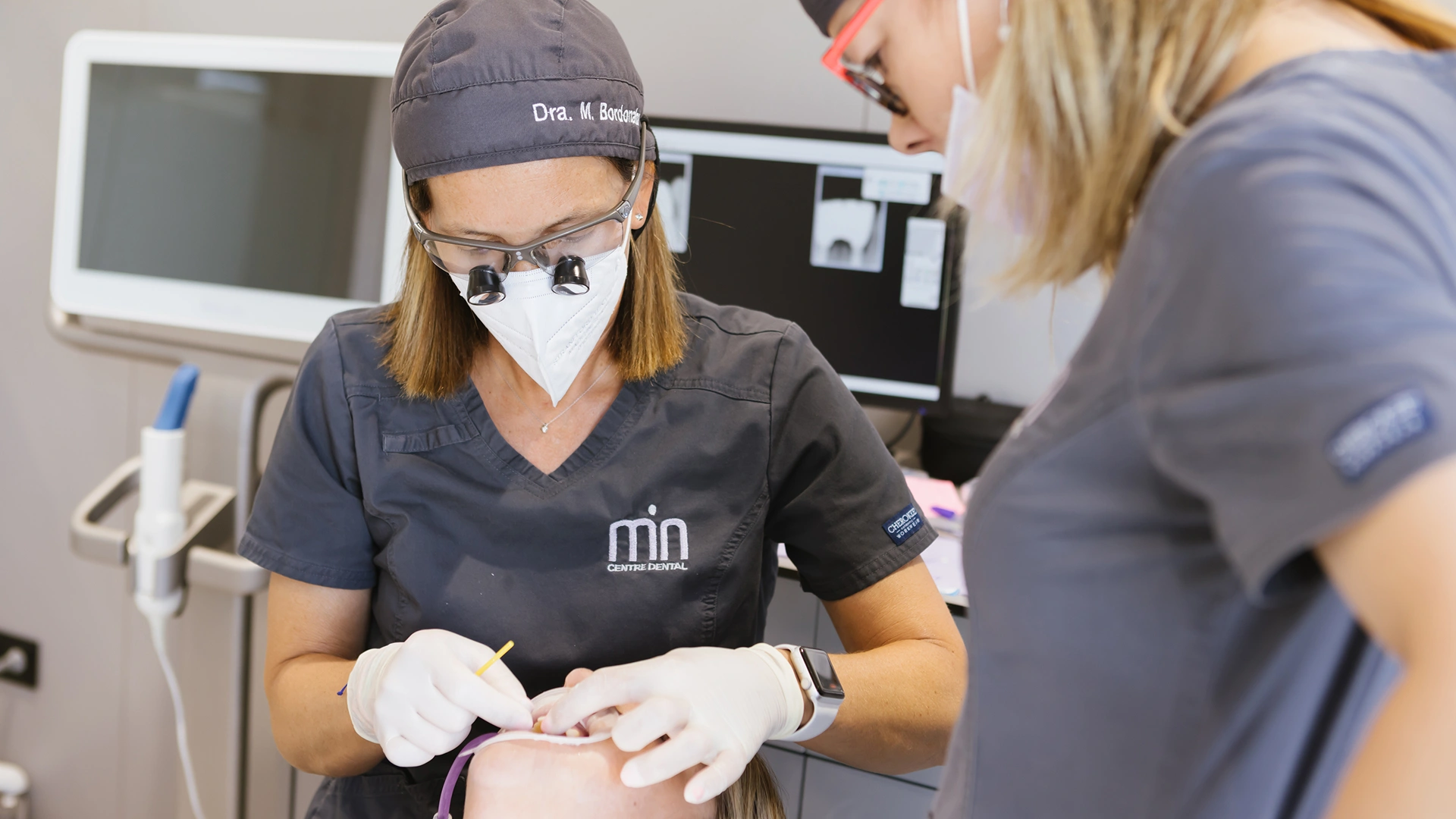 Professionals de MiN Centre Dental atenent una pacient durant una exploració bucodental.