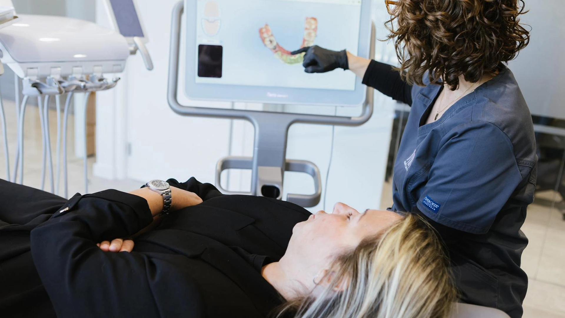 Professional de MiN Centre Dental explicant una radiografia panoràmica a un pacient durant la consulta.